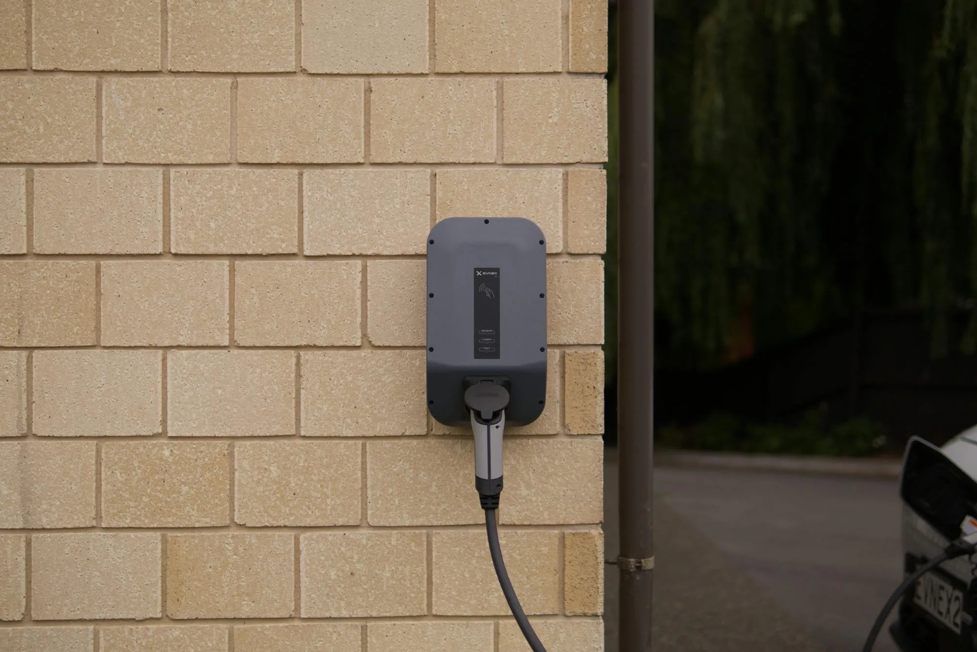 Wallbox EV zamontowany na ceglanej ścianie domu